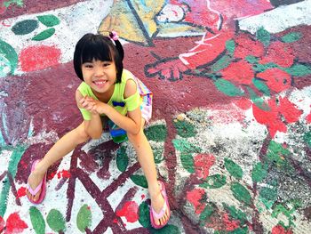 Portrait of smiling girl against wall