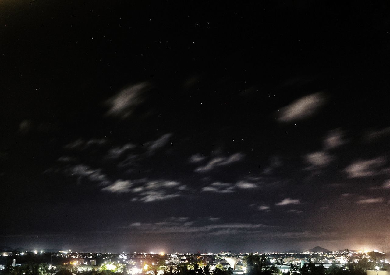 LOW ANGLE VIEW OF ILLUMINATED CITY AGAINST SKY