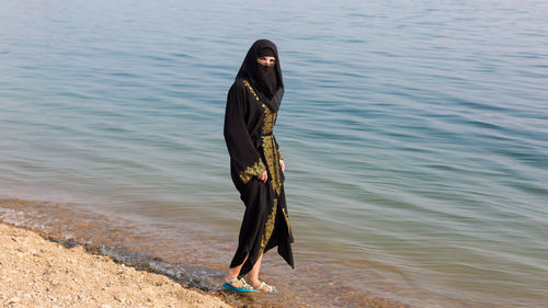 Full length of woman standing on beach