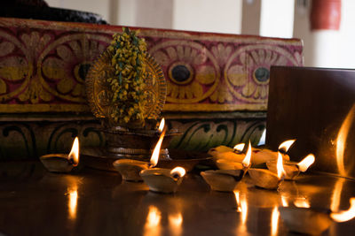 Close-up of illuminated candles on table