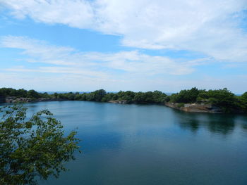 Scenic view of trees and lake against cloudy sky