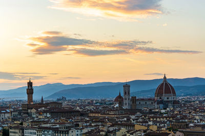 View of buildings in city at sunset