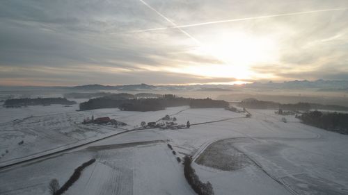 Scenic view of snowy landscape against sky during sunset