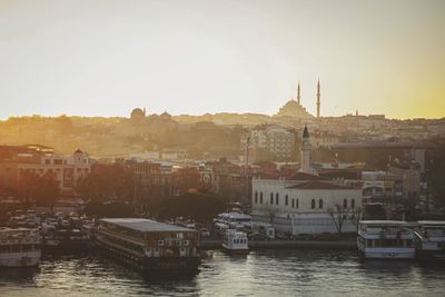 Boats in river with buildings in background