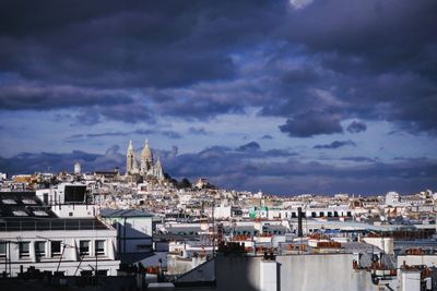 Cityscape by sea against sky