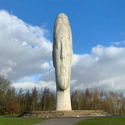 Low angle view of sculpture on field against sky