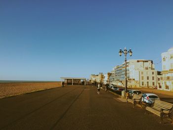 People walking along road in city next to beach