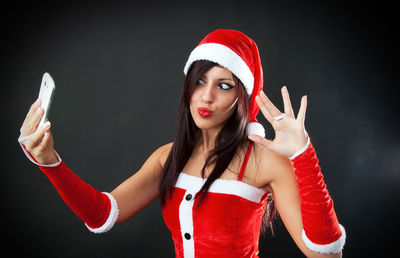 Portrait of beautiful young woman against black background