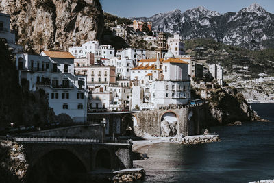 Bridge over river by buildings in city