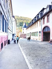 People walking on street amidst buildings in city