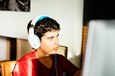Boy listening music while using computer