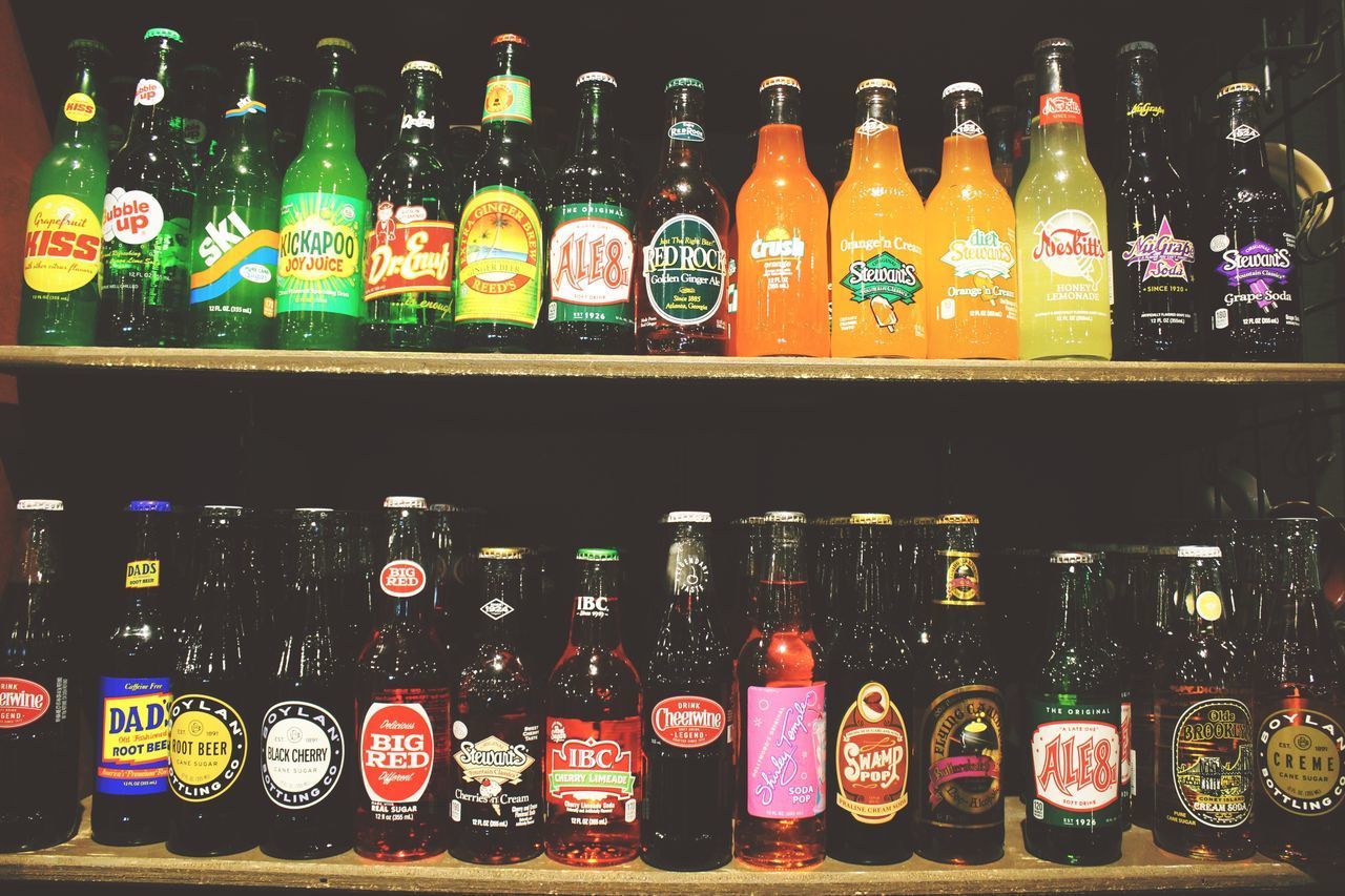 FULL FRAME SHOT OF MULTI COLORED BOTTLES IN SHELF