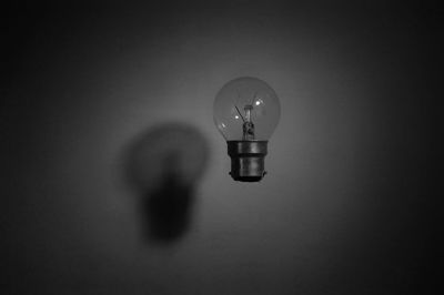 Close-up of light bulb levitating against wall