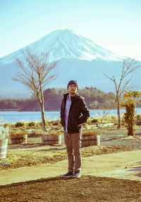 Full length of young man standing against tree