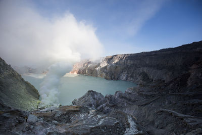 Smoke emitting from volcanic mountain against sky