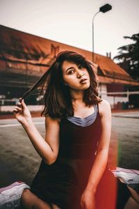 Portrait of beautiful young woman standing against wall