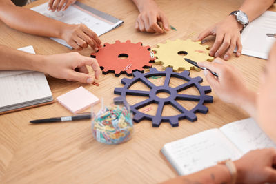 Cropped hands of business colleagues working on table