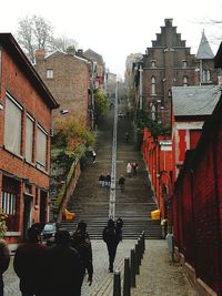 People on street amidst buildings in city