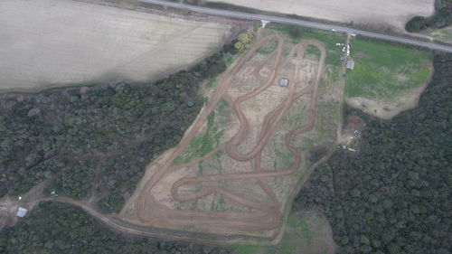 High angle view of airplane flying over agricultural field