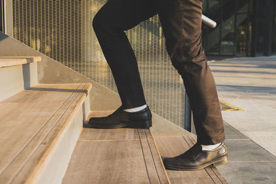 Low section of man standing on staircase