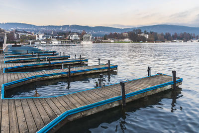 Pier over lake against sky in city