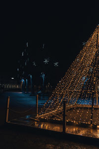 Illuminated city against sky at night