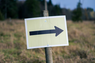 Close-up of road sign on field