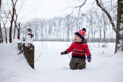 Full length of woman standing on snow covered field