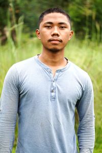 Portrait of young man standing on field