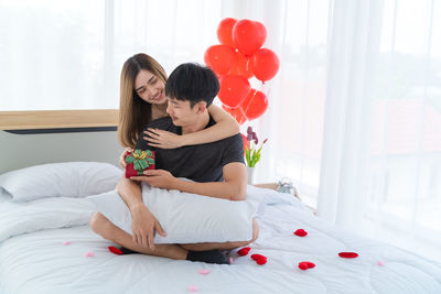 Couple sitting on bed in bedroom