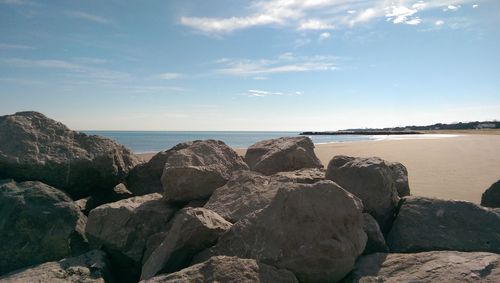 Rocks on beach against sky