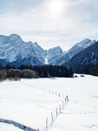 Scenic view of snow covered field against sky