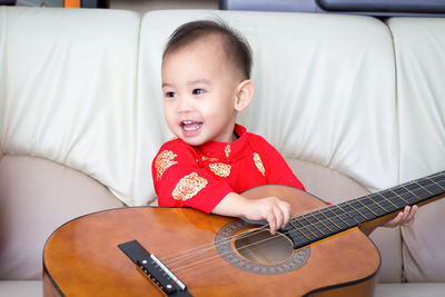 Portrait of cute boy playing guitar