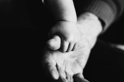 Close-up of baby hand against black background