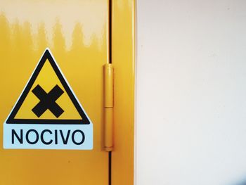 Close-up of yellow sign on wall