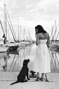 Dog and woman looking at camera against sky