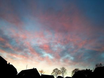 Low angle view of silhouette tree against cloudy sky