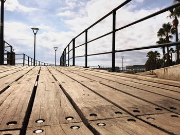 Surface level of empty benches against sky