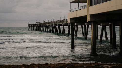 Pier over sea against sky during sunset