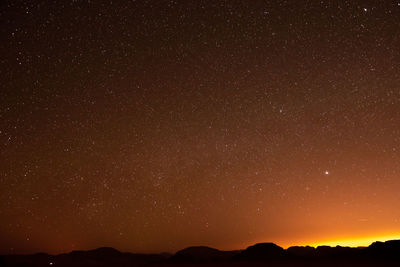 Low angle view of silhouette mountain against sky at night