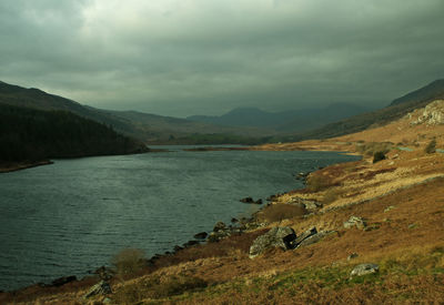 Scenic view of river and mountains against sky