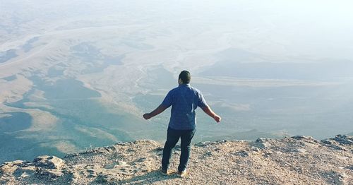 Rear view of man standing on mountain
