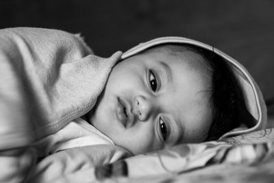 Portrait of cute baby boy lying in bed