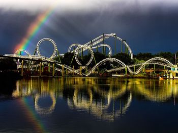 Scenic view of rainbow over river against sky