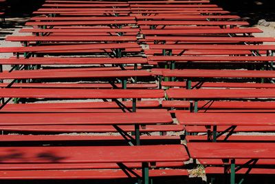 High angle view of empty benches arranged outdoors during sunny day