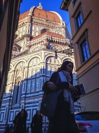 Low angle view of woman standing in front of building