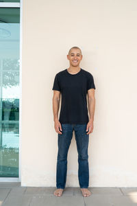 Portrait of young man standing against wall