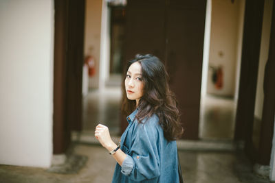 Portrait of beautiful woman standing in corridor