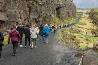 Rear view of people walking on mountain road