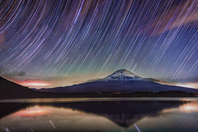 Scenic view of lake against sky at night